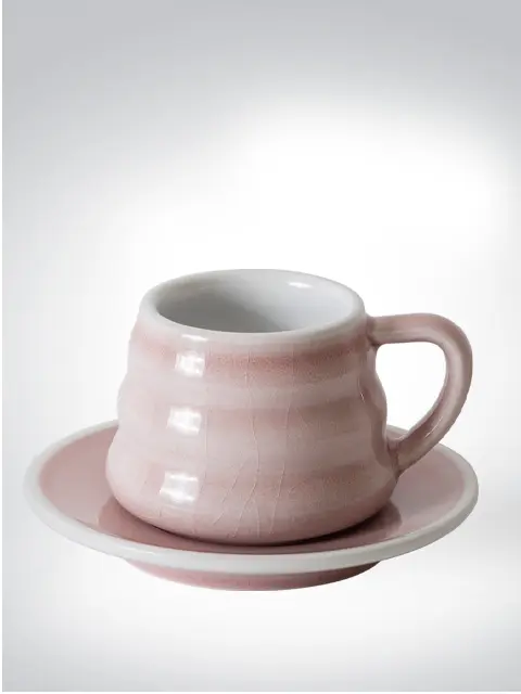 Stylish pink coffee cup with matching saucer on light background