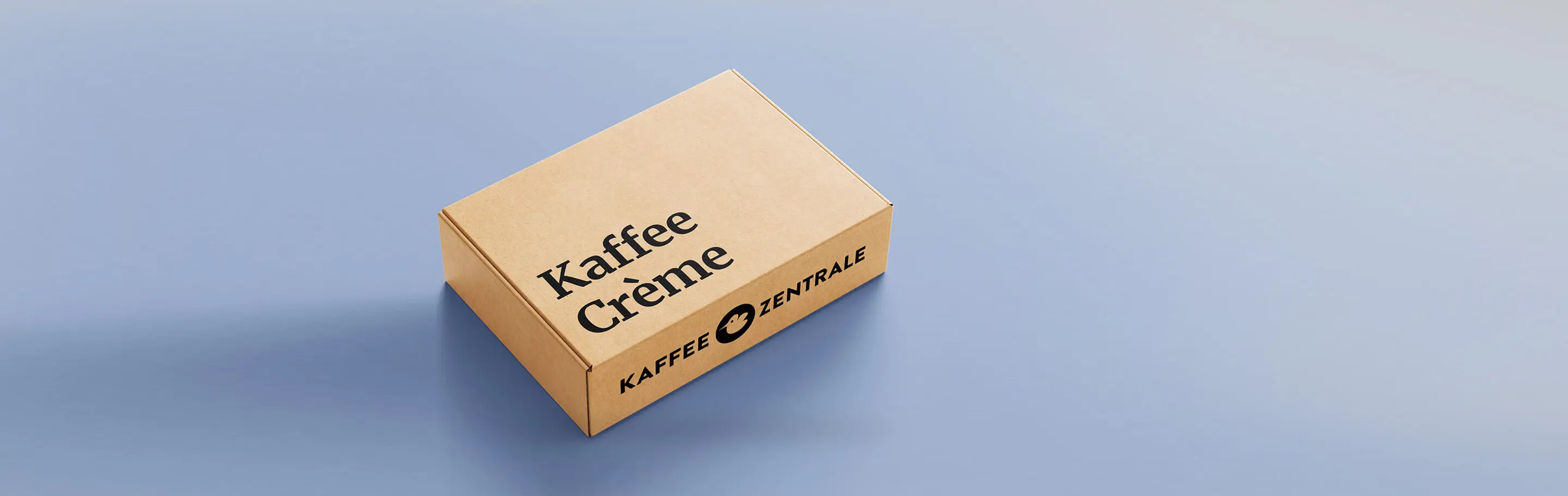 Kartonverpackung der Kaffeezentrale, beschriftet mit 'Kaffee Crème', auf blauem Hintergrund