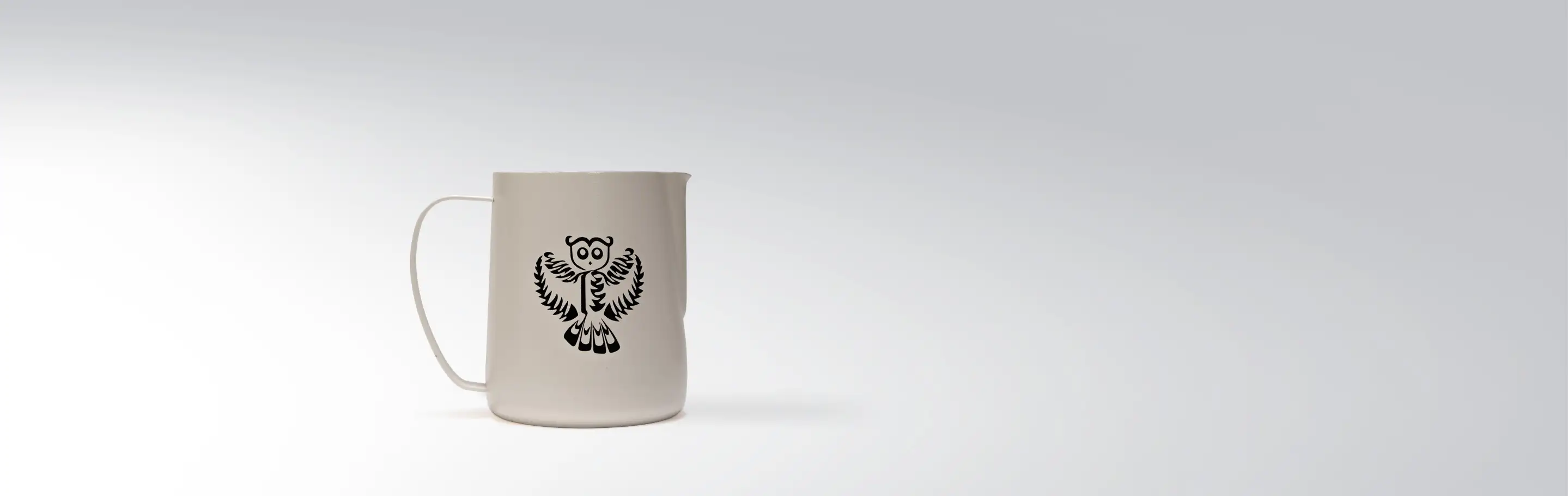 Ceramic jug with owl motif on light background