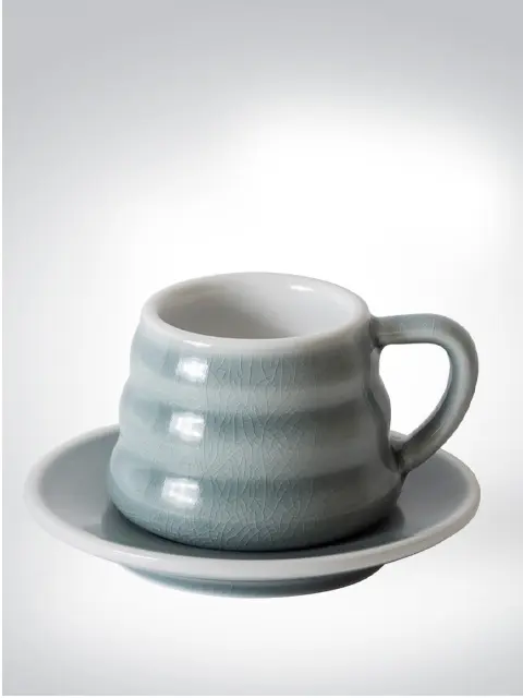 Ceramic mug with textured surface and matching saucer, in grey