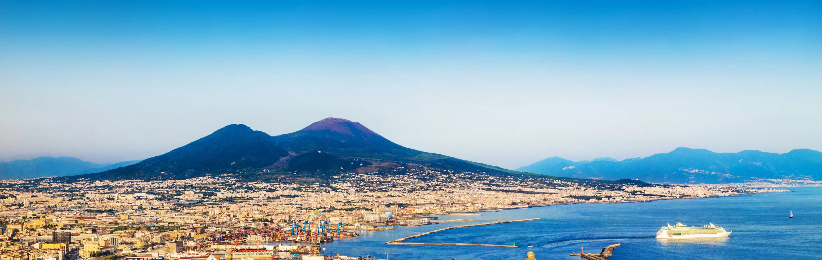 View of Mount Vesuvius and the city of Naples with a cruise ship in the foreground