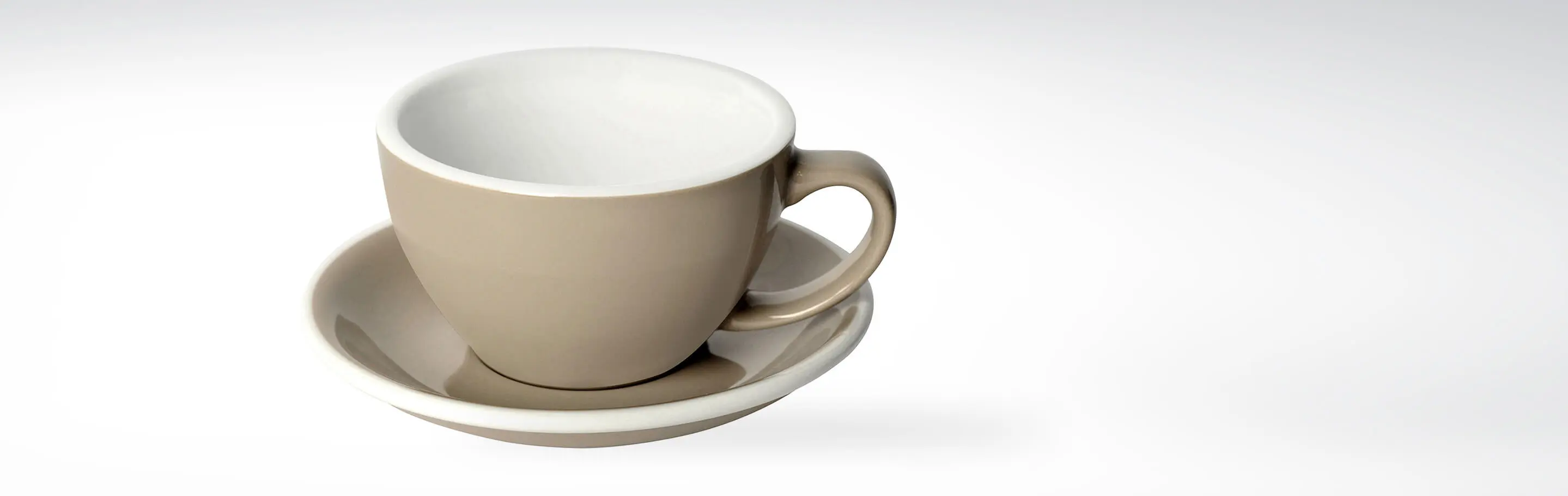 Beige Teetasse mit passender Untertasse aus Keramik auf weißem Hintergrund