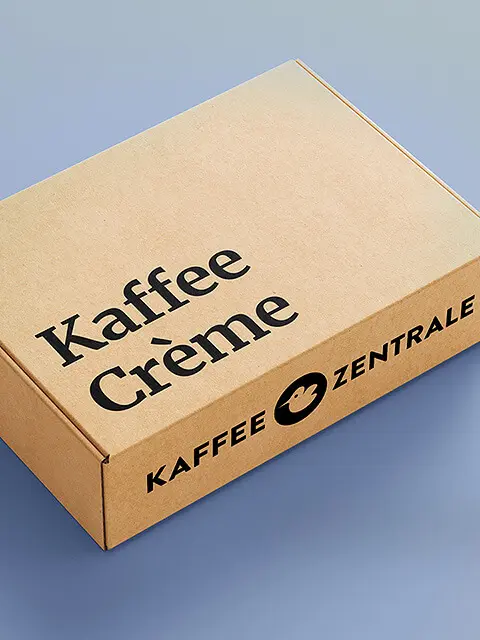 Brauner Versandkarton der Kaffee Zentrale mit der Aufschrift Kaffee Crème, auf grauem Hintergrund