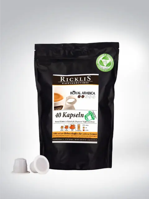 Packung Ricklis Kaffeerösterei Royal Arabica mit 40 Kapseln, umgeben von Kaffeekapseln. Hochwertiger Arabica-Kaffee für Kapselmaschinen.