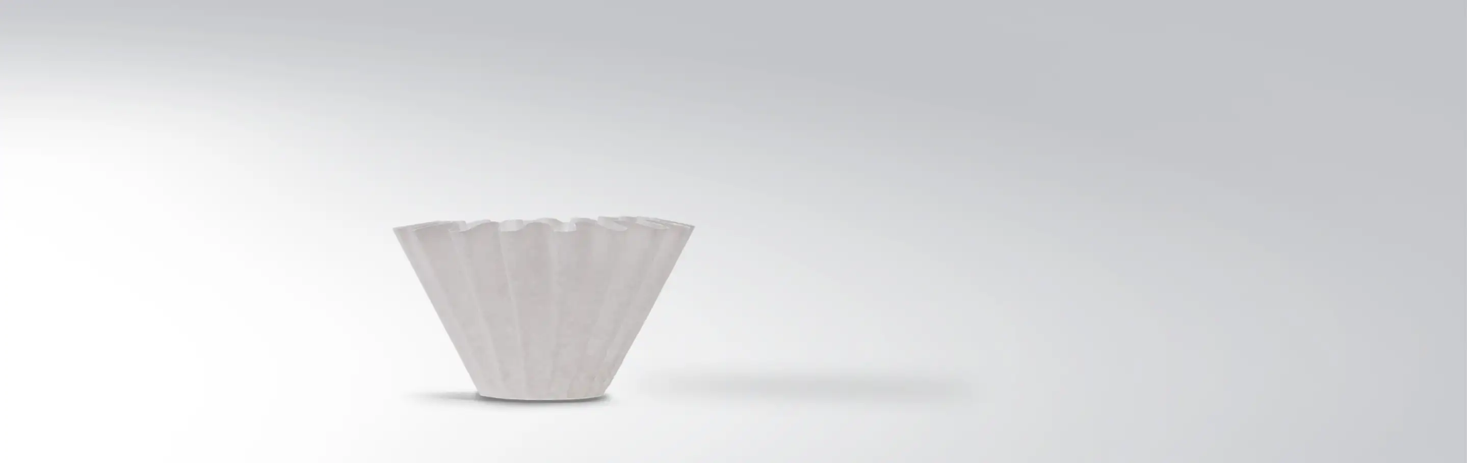 A white coffee filter against a grey background