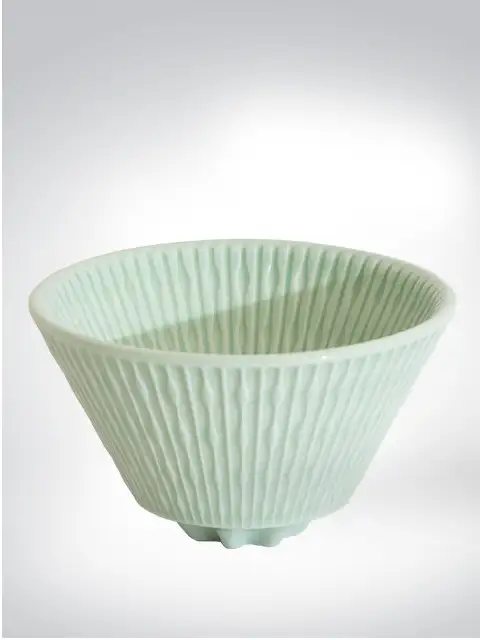 An elegant green ceramic bowl with unique ribbed texture