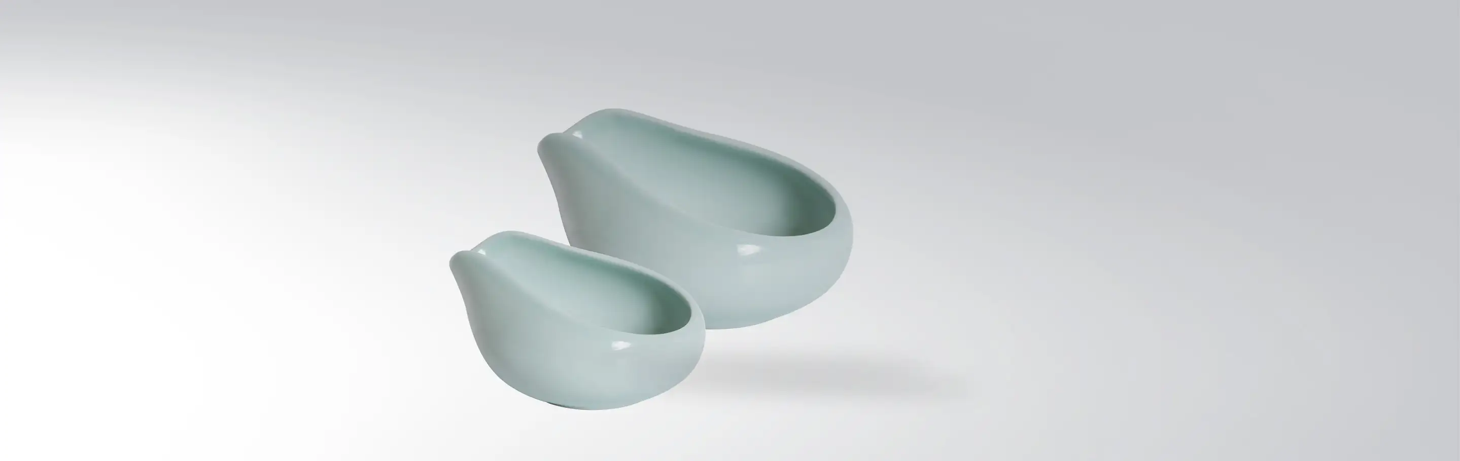 Two modern, mint green ceramic bowls of different sizes