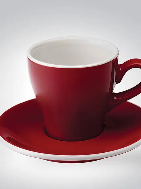 Rote Keramiktasse mit passender Untertasse auf neutralem Hintergrund