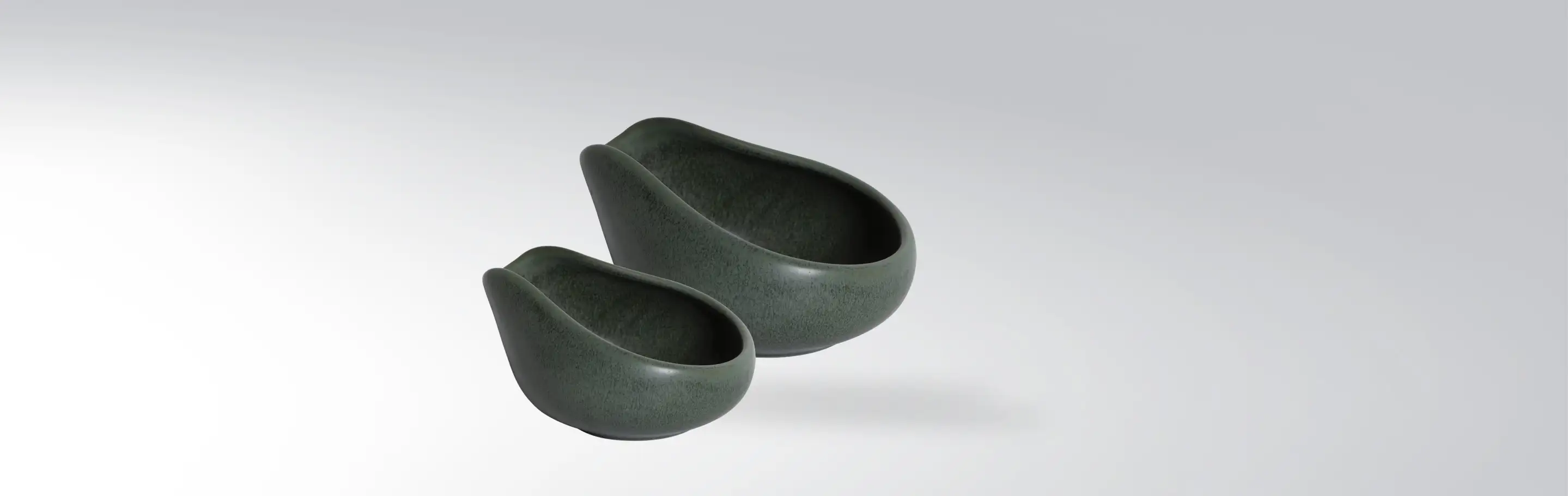 Two modern green ceramic bowls on grey background