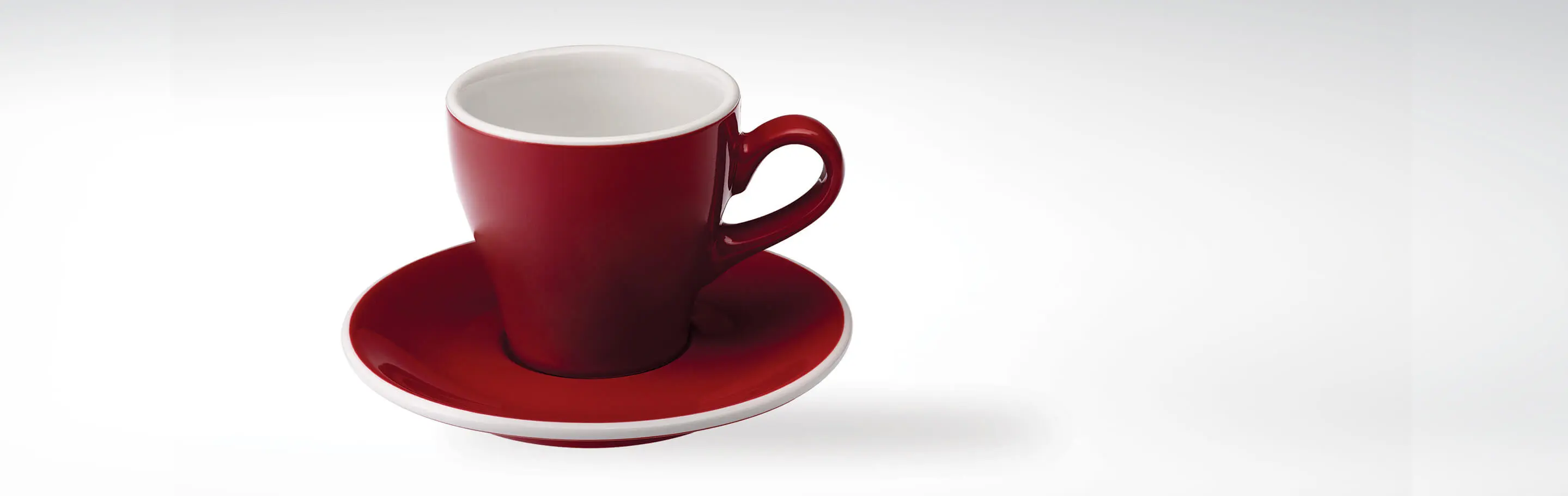 Rote Kaffeetasse mit passender Untertasse auf weißem Hintergrund
