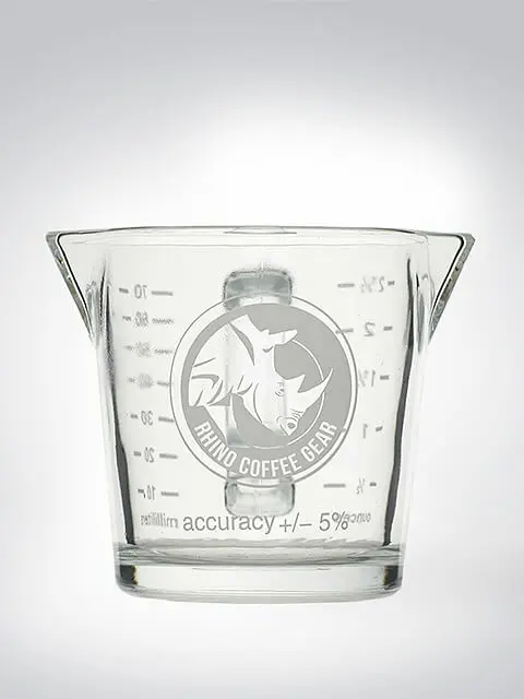 Glas-Messbecher von Rhino Coffee Gear mit Skalierung und Logo, ideal für präzises Abmessen von Flüssigkeiten.