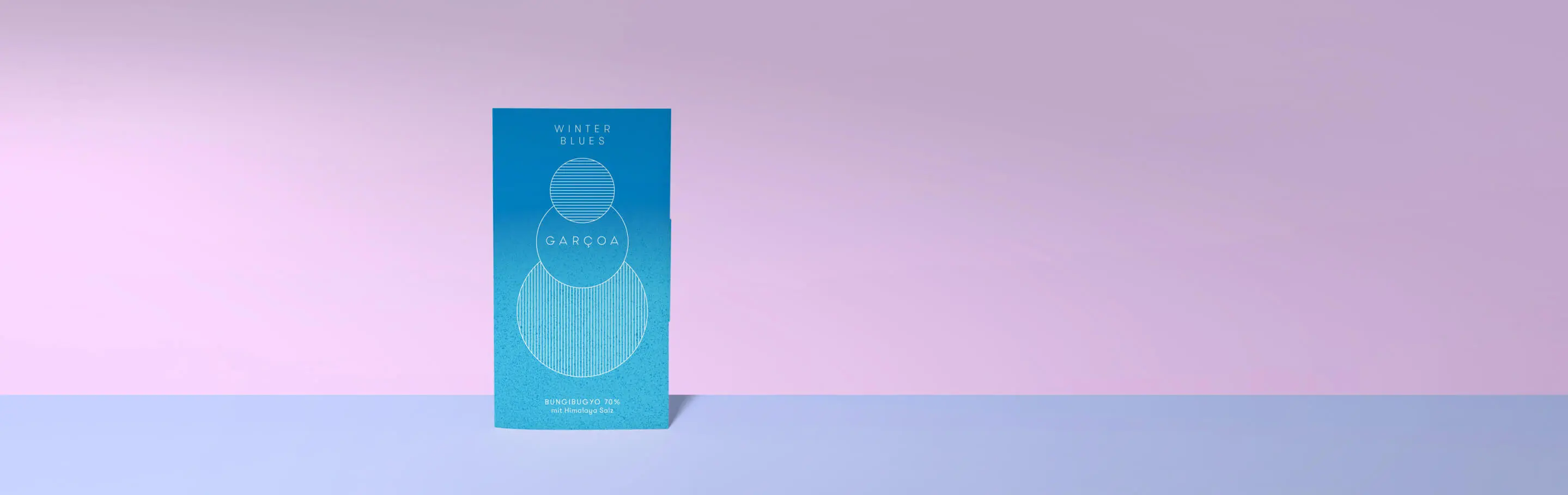 Packaging of Garçoa Winter Blues chocolate, Bungibuqyo 70% cocoa, with Himalayan salt on a pastel-coloured background