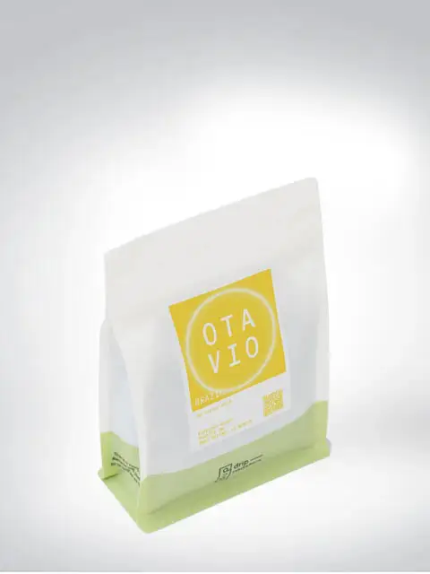 Weiße Verpackung mit gelbem Etikett von Otavio Kaffee, brasilianischer Ursprung.